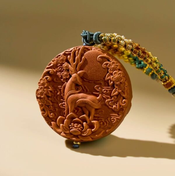 Carved clay disk with deer and floral design.