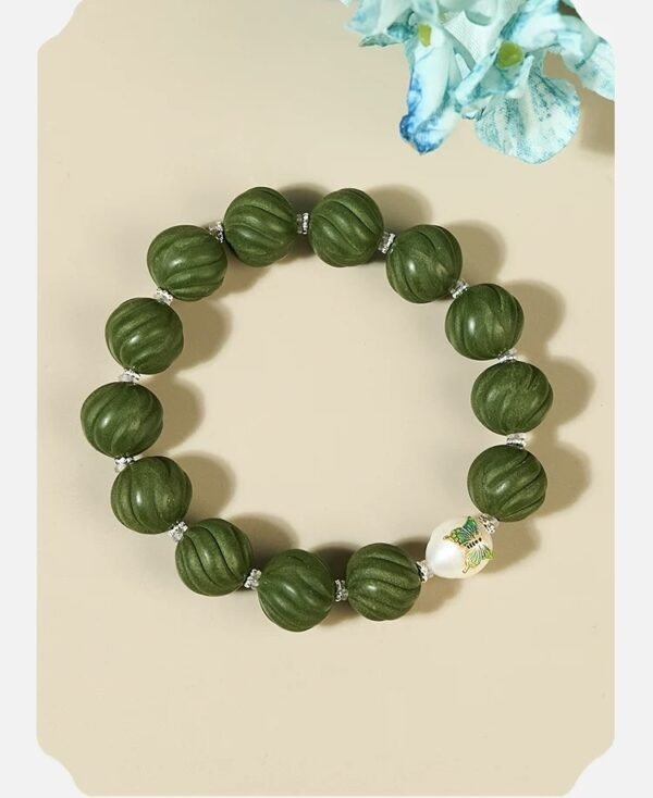 Green bead bracelet with floral accents on display
