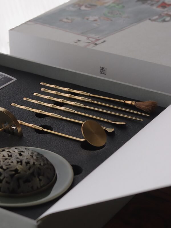 Yue Kiln Celadon incense tools set page, featuring gold incense tools and a celadon burner in a white box, designed for traditional Chinese herbal incense practices on a wooden table.