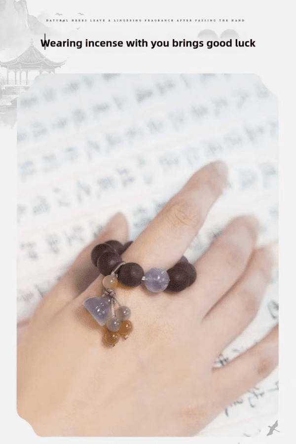 Hand wearing incense bead bracelet for good luck.