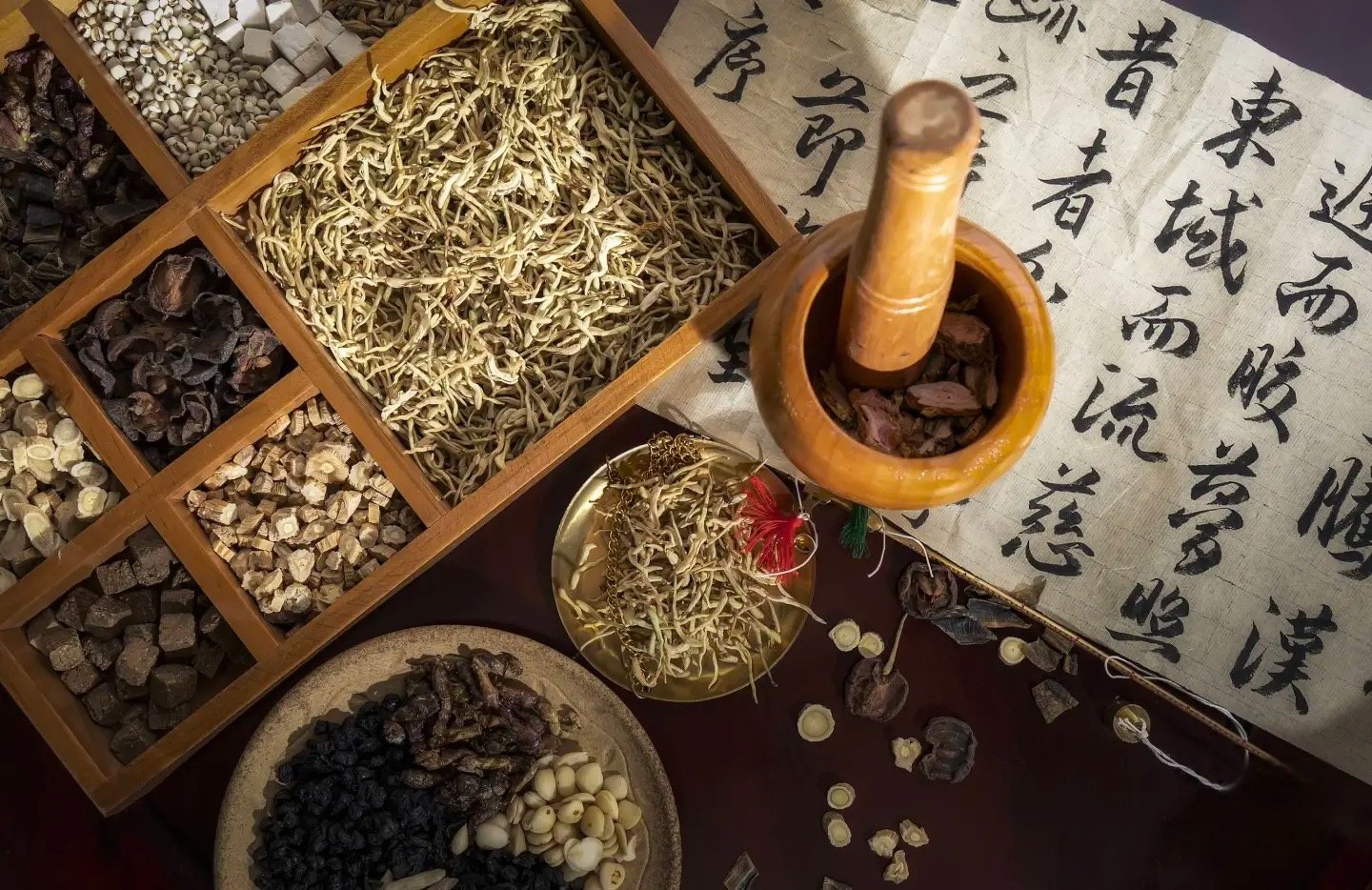 Dried Chinese medicinal roots and herbal ingredients in wooden compartments